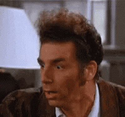 A Close Up Of A Man 'S Face With His Mouth Open And A Lamp In The Background . GIF