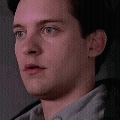 a close up of a man 's face with his mouth open and a surprised look on his face .