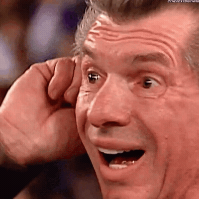 A Close Up Of A Man 'S Face With His Mouth Open And His Hand Covering His Ear . GIF