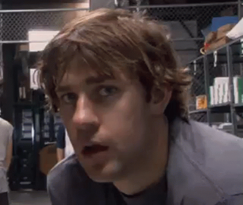 A Close Up Of A Man 'S Face With His Mouth Open In A Warehouse . GIF