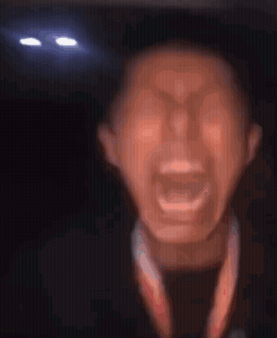 a close up of a man 's face with his mouth open