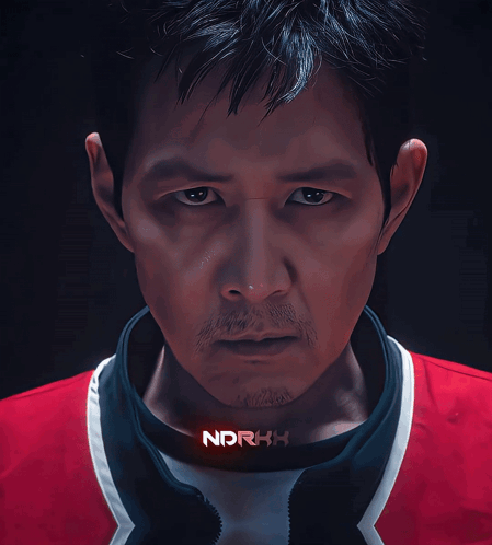 A Close Up Of A Man 'S Face With Ndrkh Written On His Collar GIF