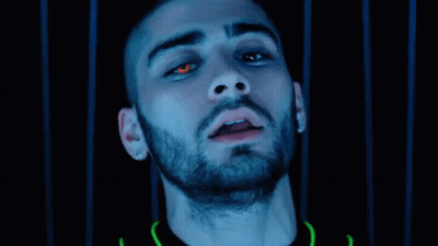 A Close Up Of A Man 'S Face With Red Eyes And A Beard In A Dark Room . GIF
