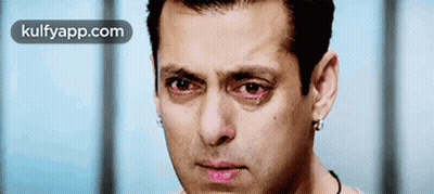 A Close Up Of A Man 'S Face With Red Eyes And The Words Kulfyapp.com Below Him GIF
