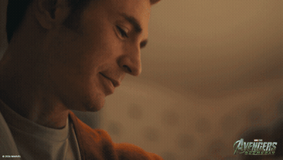 A Close Up Of A Man 'S Face With The Avengers Logo In The Corner GIF