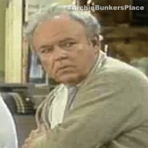 a close up of a man 's face with the words `` archiebunkersplace '' on the bottom .