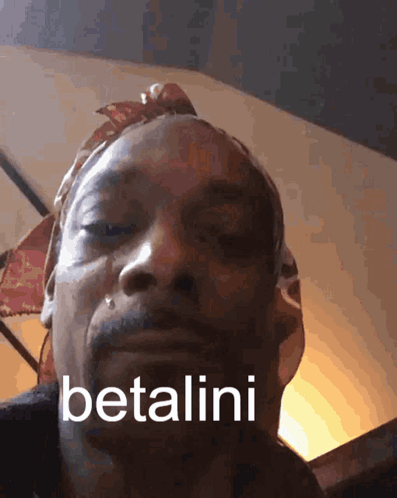 A Close Up Of A Man 'S Face With The Words Betalini Written On It GIF