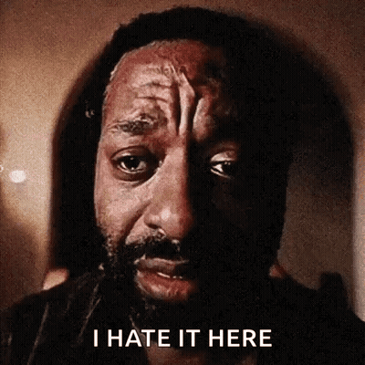 a close up of a man 's face with the words `` i hate it here '' written on the bottom .
