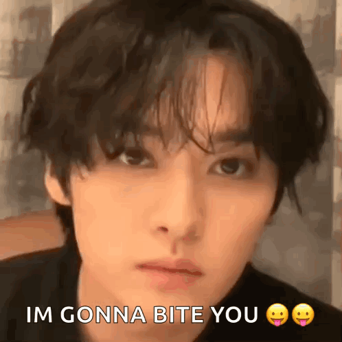 A Close Up Of A Man 'S Face With The Words `` Im Gonna Bite You '' Written On It . GIF