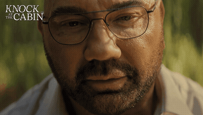 A Close Up Of A Man 'S Face With The Words " Knock At The Cabin " Behind Him GIF