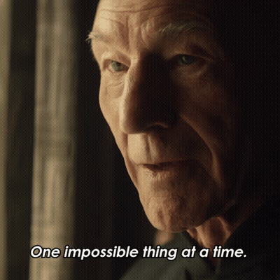 A Close Up Of A Man 'S Face With The Words One Impossible Thing At A Time Below It GIF