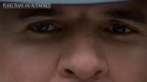 A Close Up Of A Man 'S Face With The Words " Planes Trains And Automobiles " On The Bottom GIF