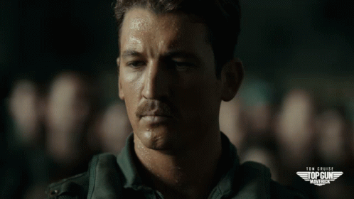 A Close Up Of A Man 'S Face With The Words Tom Cruise 'S Top Gun Marines On The Bottom GIF