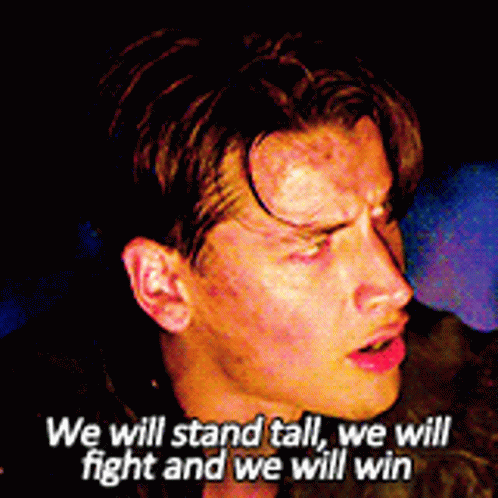 A Close Up Of A Man 'S Face With The Words We Will Stand Tall We Will Fight And We Will Win Above Him GIF