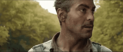 A Close Up Of A Man 'S Face With Trees In The Background And A Blurred Background . GIF