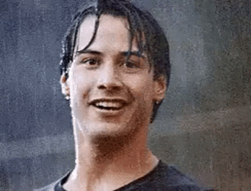 A Close Up Of A Man 'S Face With Wet Hair Smiling In The Rain . GIF