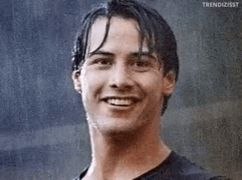 A Close Up Of A Man 'S Face With Wet Hair Smiling In The Rain . GIF