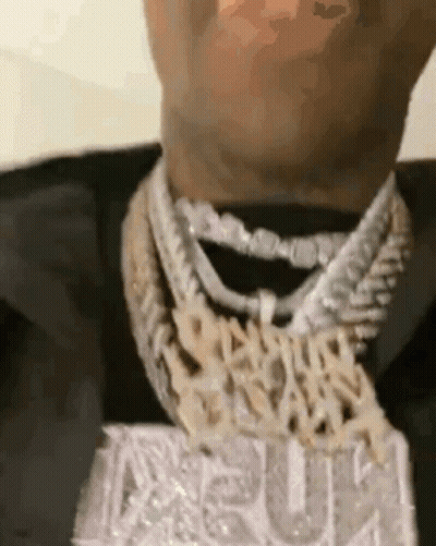 A Close Up Of A Man 'S Neck Wearing A Necklace With A Pendant . GIF