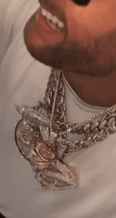 A Close Up Of A Man 'S Neck With A Necklace And A Pendant GIF