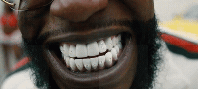 A Close Up Of A Man 'S Teeth With Rhinestones GIF