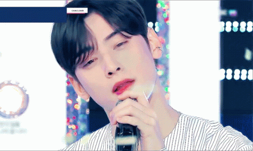 A Close Up Of A Man Singing Into A Microphone . GIF