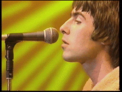 A Close Up Of A Man Singing Into A Microphone . GIF