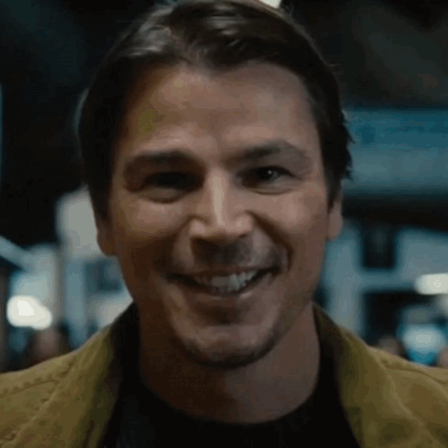 A Close Up Of A Man Smiling With A Yellow Jacket On GIF
