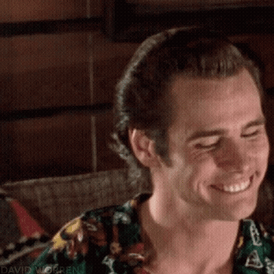 A Close Up Of A Man Smiling With His Eyes Closed And Wearing A Floral Shirt . GIF
