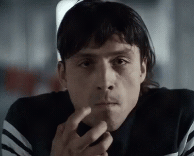 A Close Up Of A Man Smoking A Cigarette And Looking At The Camera . GIF