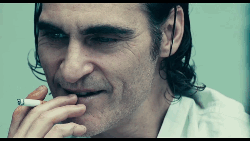 A Close Up Of A Man Smoking A Cigarette With His Mouth Open GIF