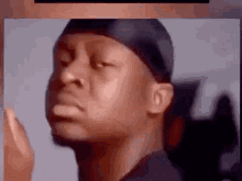 A Close Up Of A Man Wearing A Bandana And A Hat Making A Funny Face . GIF