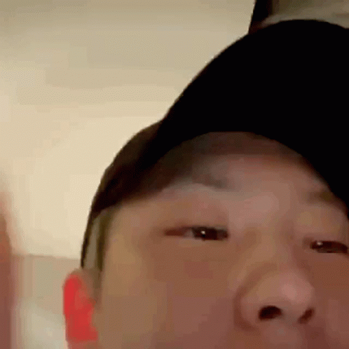 A Close Up Of A Man Wearing A Baseball Cap . GIF