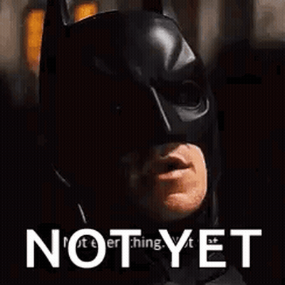 A Close Up Of A Man Wearing A Batman Mask With The Words `` Not Yet '' Above Him . GIF
