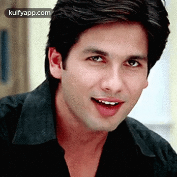A Close Up Of A Man Wearing A Black Shirt And Smiling GIF