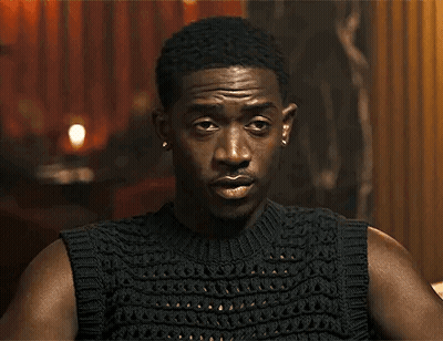 A Close Up Of A Man Wearing A Black Sleeveless Sweater GIF