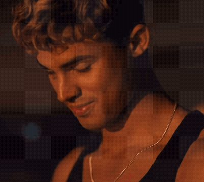 A Close Up Of A Man Wearing A Black Tank Top And A Necklace GIF