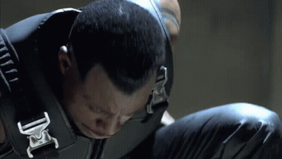 A Close Up Of A Man Wearing A Black Vest With A Buckle That Says Dc GIF