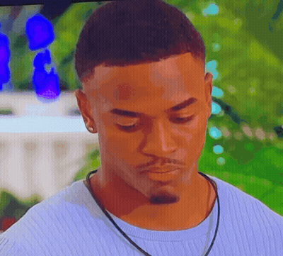 A Close Up Of A Man Wearing A Blue Sweater And A Black Necklace GIF