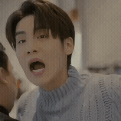 A Close Up Of A Man Wearing A Blue Sweater With His Mouth Open GIF