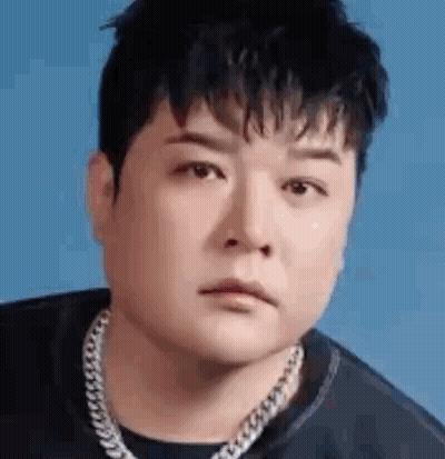 A Close Up Of A Man Wearing A Chain Around His Neck And A Black Shirt . GIF