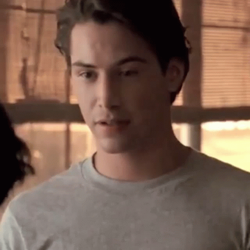 A Close Up Of A Man Wearing A Gray T-Shirt Looking At The Camera . GIF