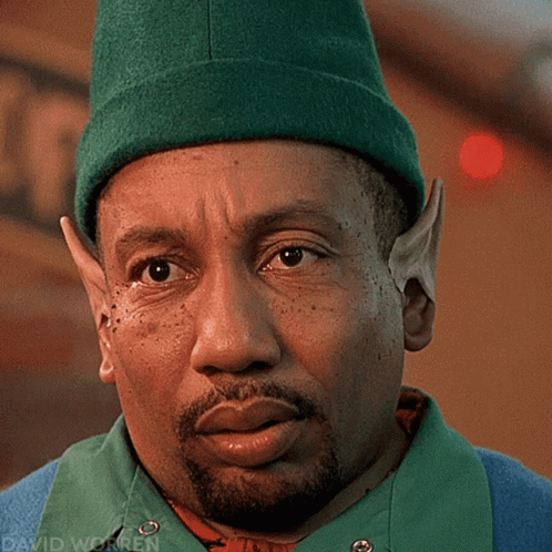 A Close Up Of A Man Wearing A Green Hat With The Name David Worren On The Bottom GIF