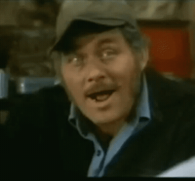 A Close Up Of A Man Wearing A Hat And A Blue Shirt GIF