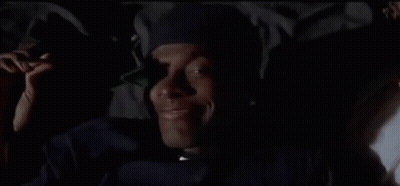A Close Up Of A Man Wearing A Hat And A Jacket In The Dark . GIF