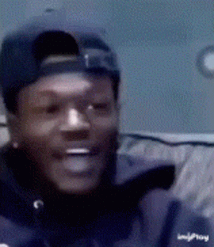 A Close Up Of A Man Wearing A Hat And A Jacket That Says Imgplay GIF