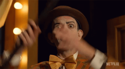 A Close Up Of A Man Wearing A Hat And Bow Tie Making A Funny Face . GIF