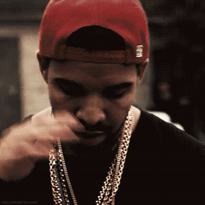A Close Up Of A Man Wearing A Hat And Chains GIF