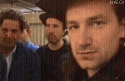 A Close Up Of A Man Wearing A Hat And Earrings Making A Funny Face . GIF