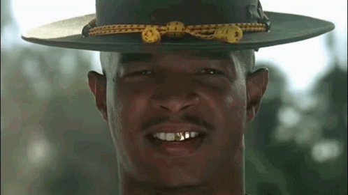 A Close Up Of A Man Wearing A Hat With Gold Teeth GIF