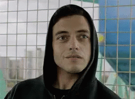 A Close Up Of A Man Wearing A Hoodie Looking At The Camera . GIF